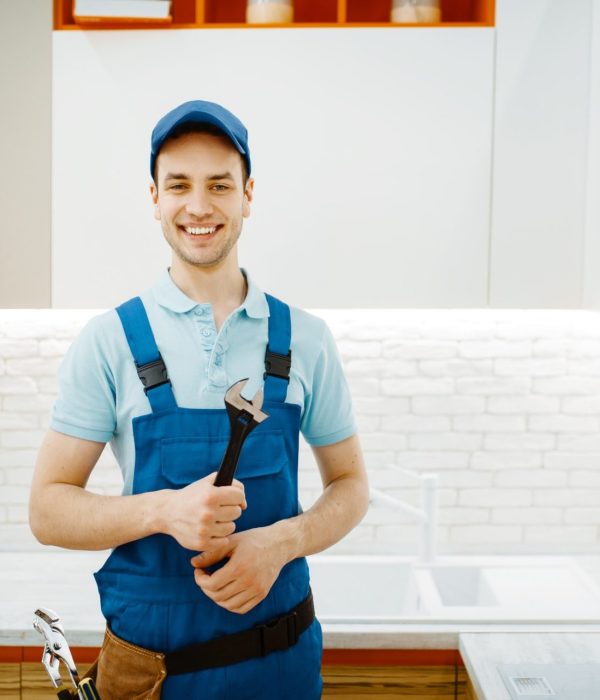 plumber-in-uniform-fixing-faucet-in-the-kitchen